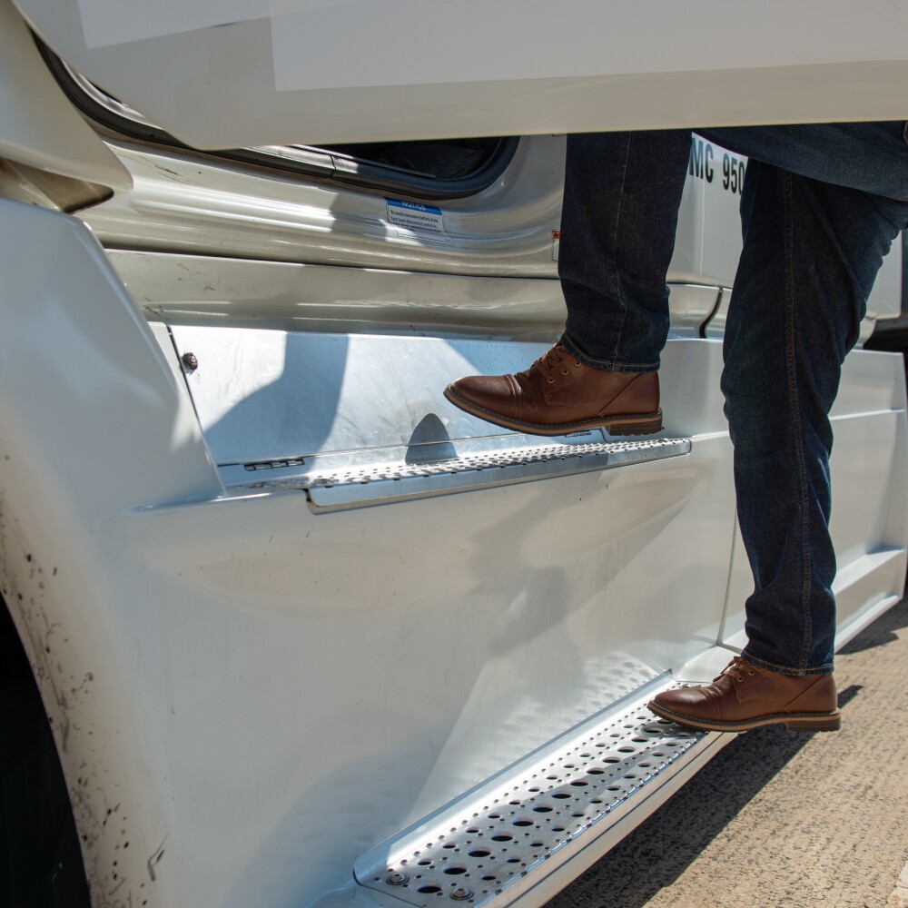 driver stepping into cab of a semi truck