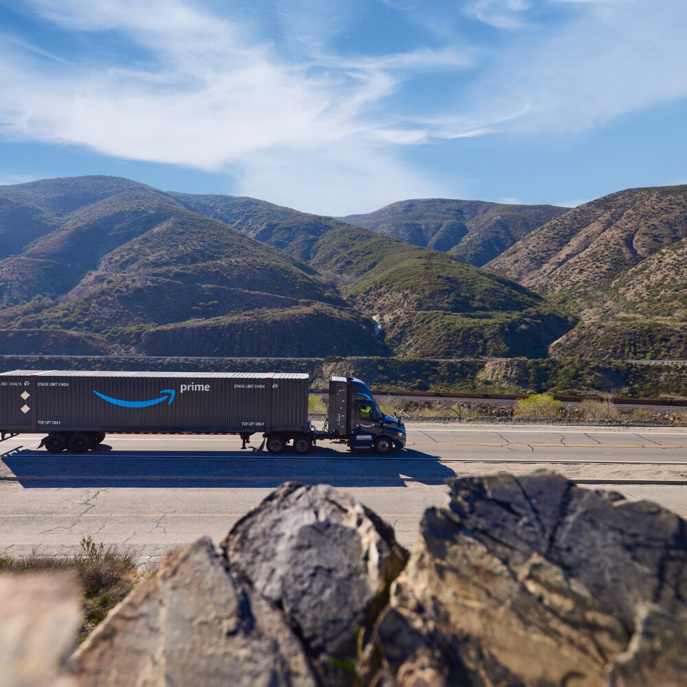 truck hauling amazon prime intermodal trailer through mountains