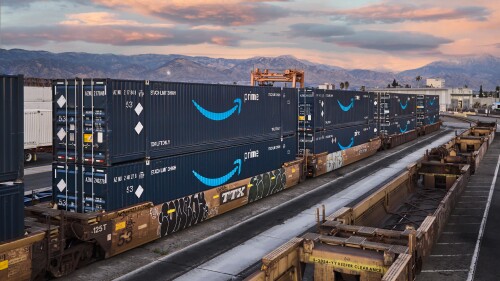 stack of amazon intermodal containers against mountain skyline