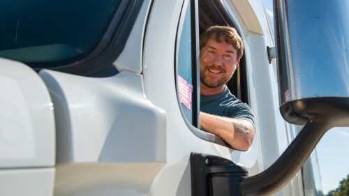 driver leaning out of the window of a semi cab