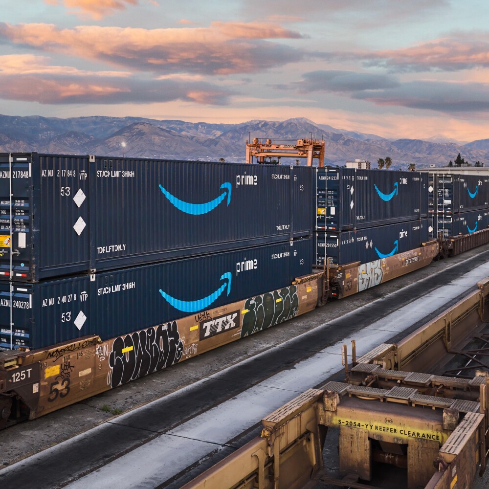 stack of amazon intermodal containers against mountain skyline