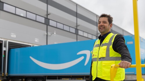 man standing in amazon yard next to prime trailer.jpg