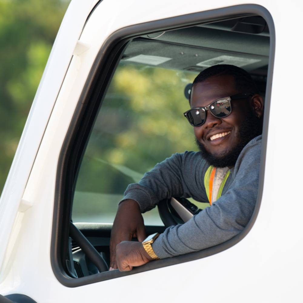 smiling driver in semi cab.png
