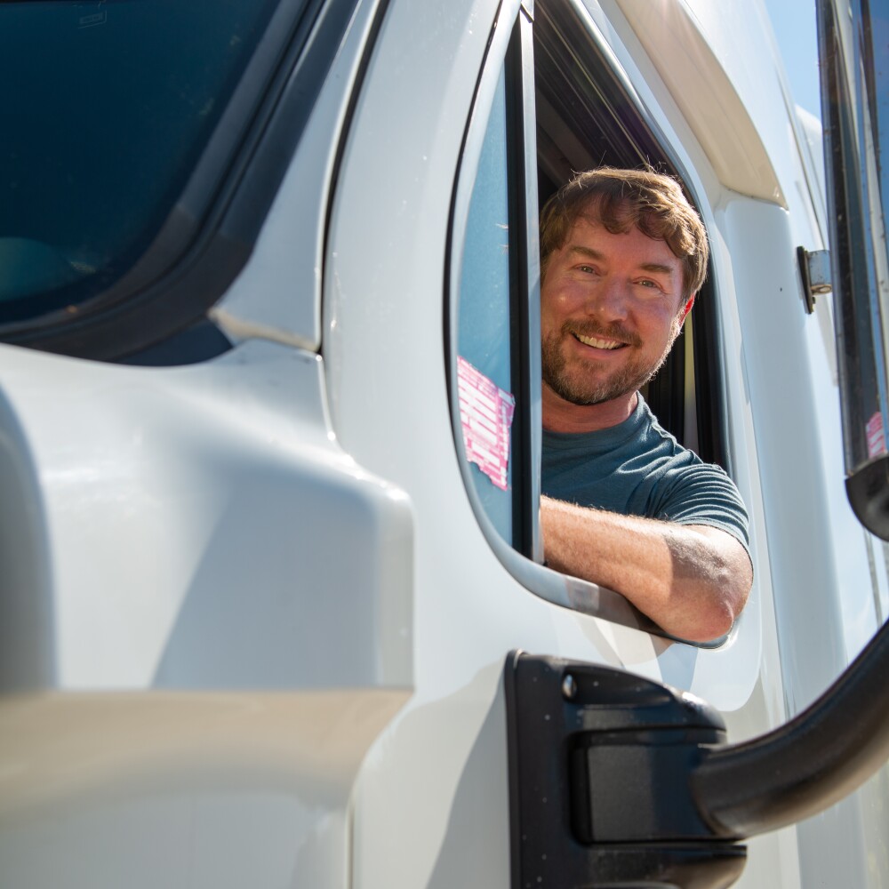 driver leaning out of the window of a semi cab