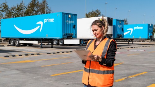 trucker standing in a truck yard with a clipboard.jpg