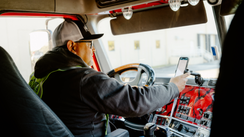 truck driver in cab using Amazon Relay mobile app